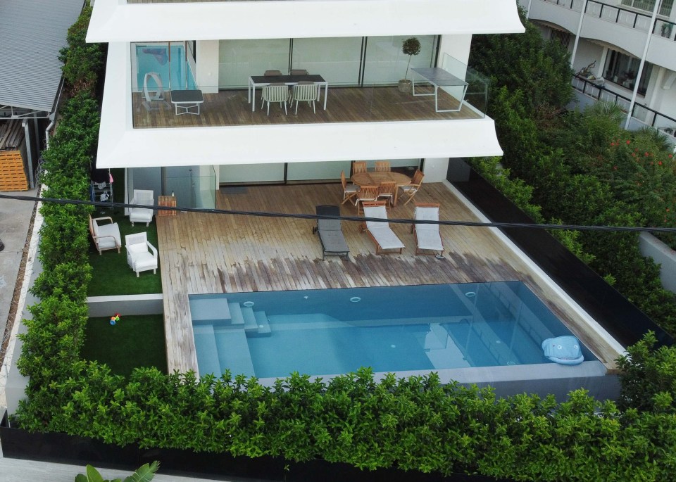 an aerial view of a house with a large swimming pool