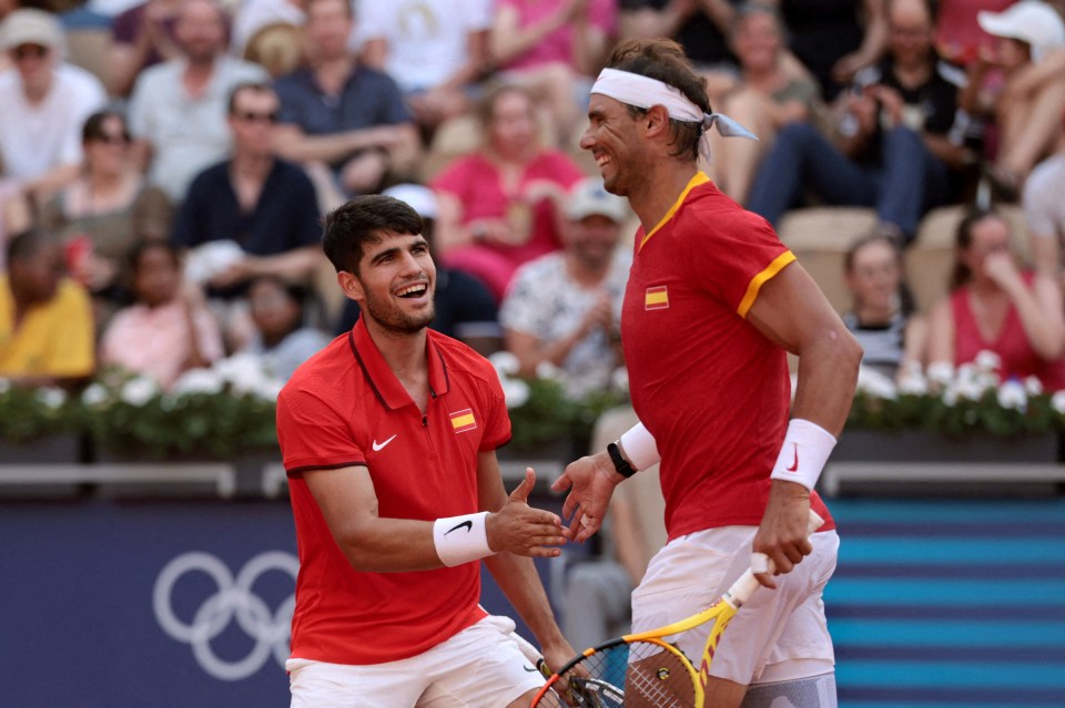 two tennis players wearing red shirts with the spanish flag on them