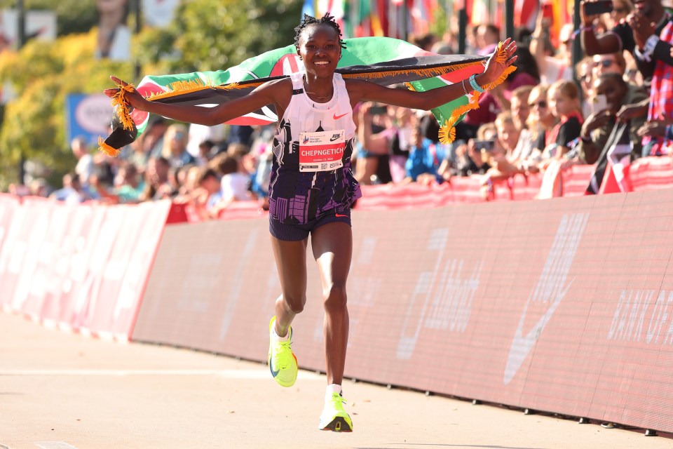 a woman crosses the finish line of the pro women marathon