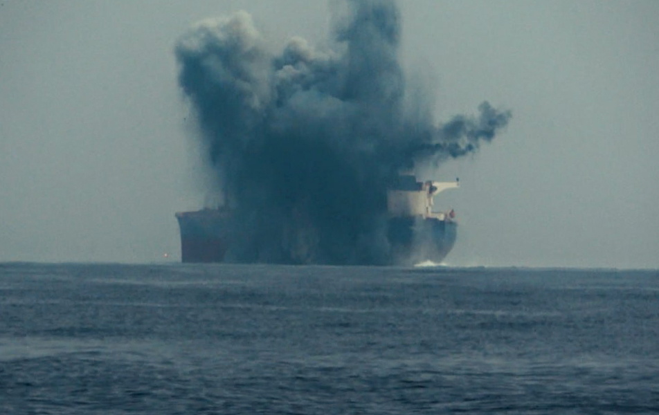 a large ship in the ocean with smoke coming out of it