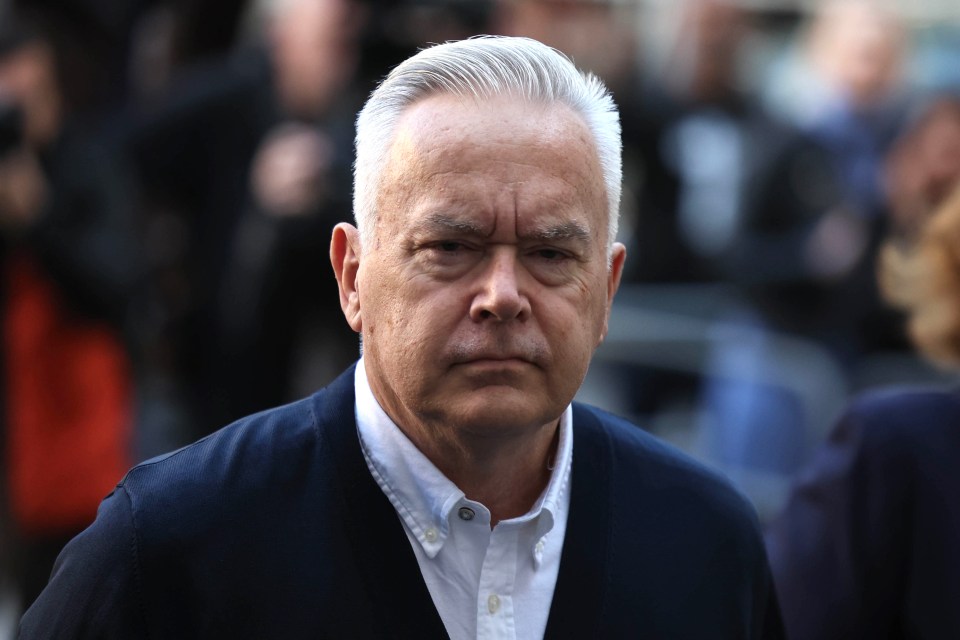 a man with gray hair is wearing a blue jacket and white shirt