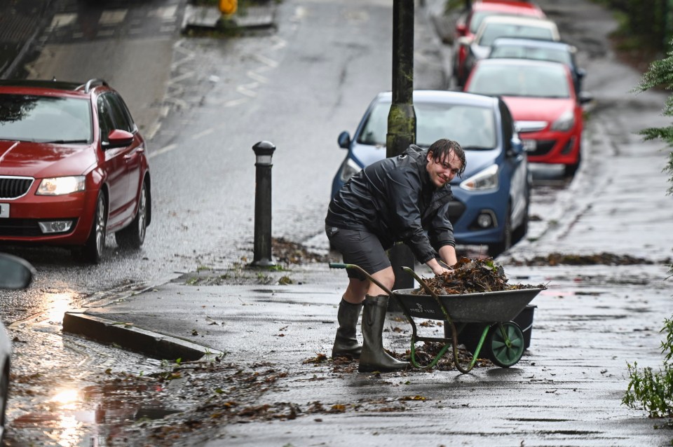 Locals take matters into their own hands and remove fallen leaves from blocked drains in Broom Hill, Bristol