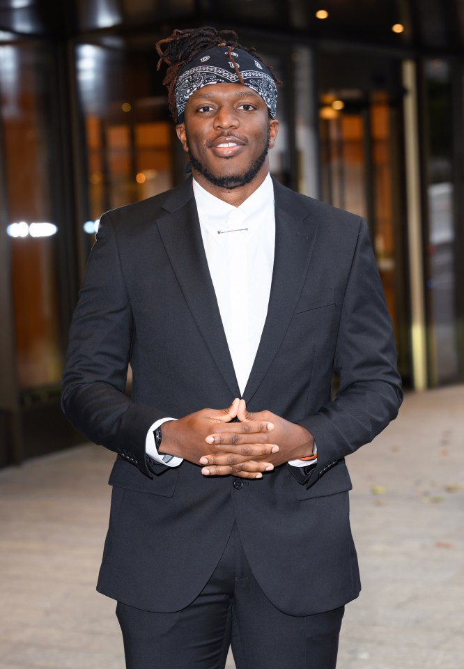 a man in a suit and tie with a bandana on his head