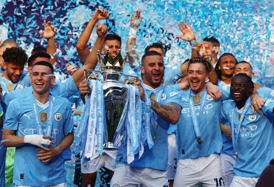 a group of soccer players holding up a trophy that says premier league