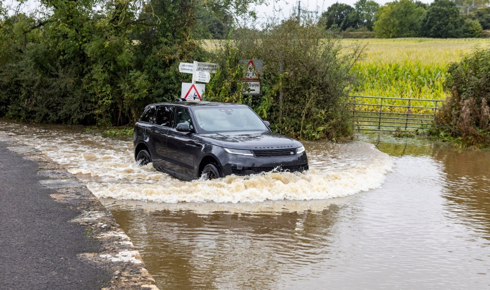 A Range Rover pushes through a flooded road in Wiltshire on Wednesday