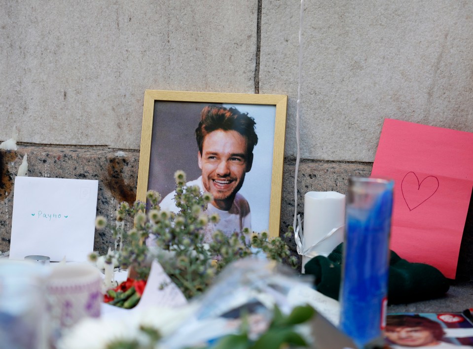 a picture of a smiling man is surrounded by flowers and candles