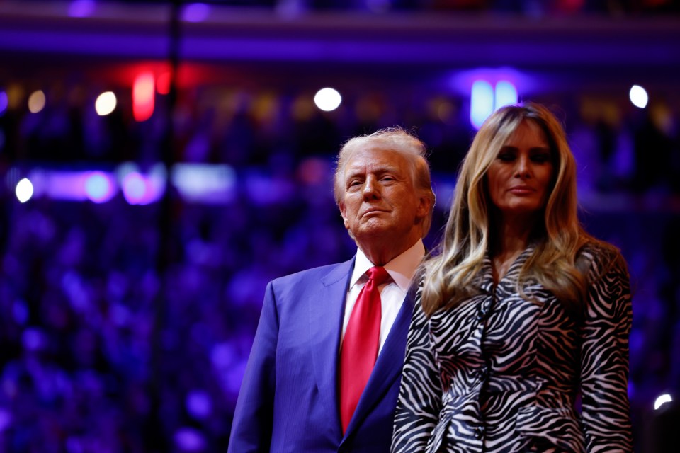 a man in a suit and tie stands next to a woman in a zebra print dress