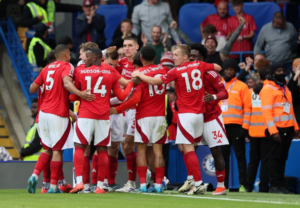 a group of soccer players huddle together with one wearing the number 18