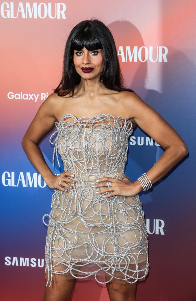 a woman in a strapless dress stands in front of a glamour sign