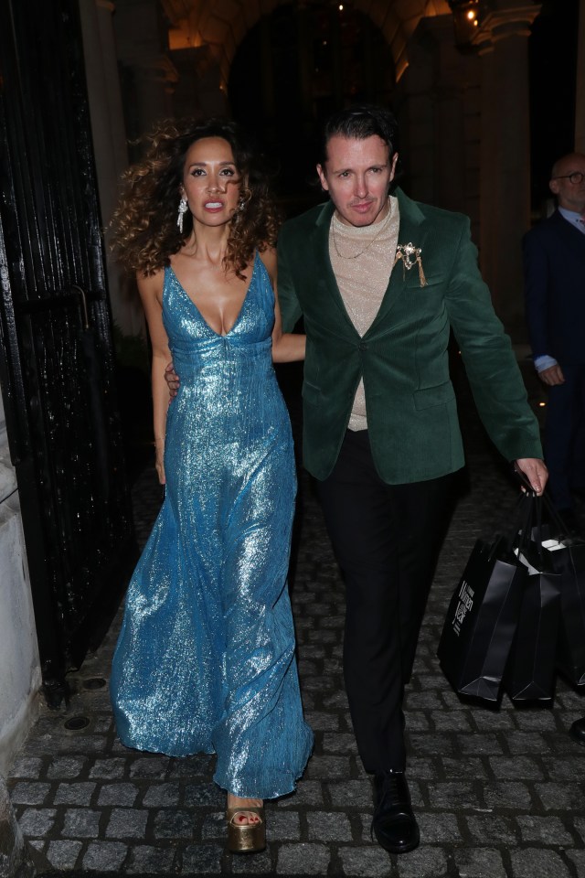 a woman in a blue dress is walking with a man in a green jacket