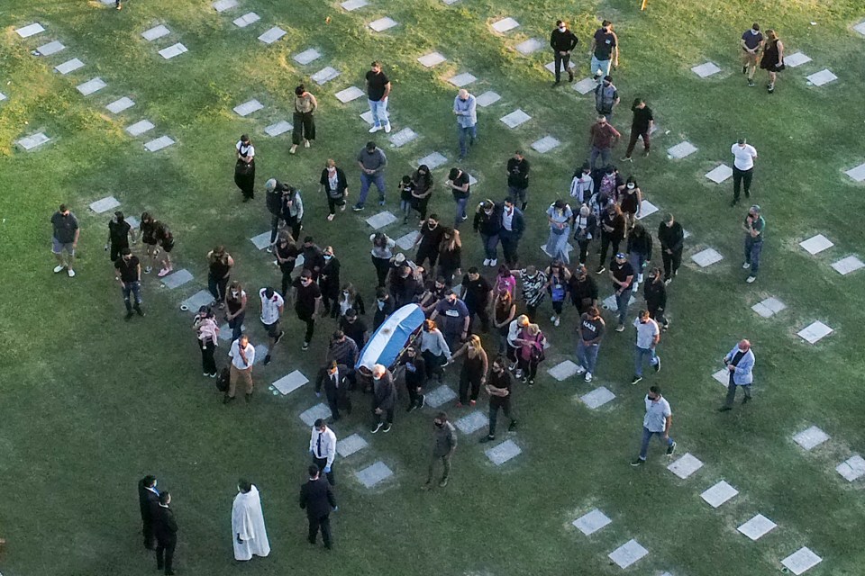 a large group of people are gathered in a cemetery