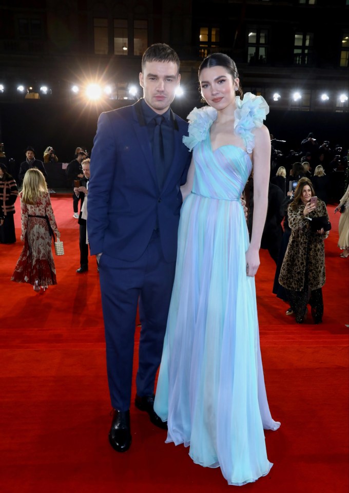 a man and a woman pose for a picture on a red carpet