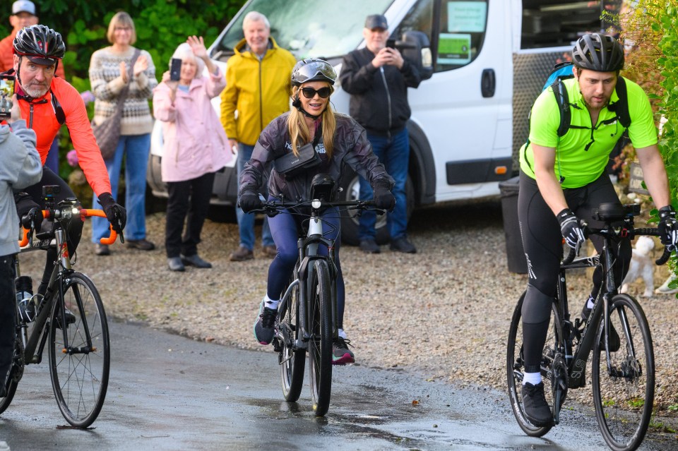 a woman wearing a helmet and sunglasses is riding a bike