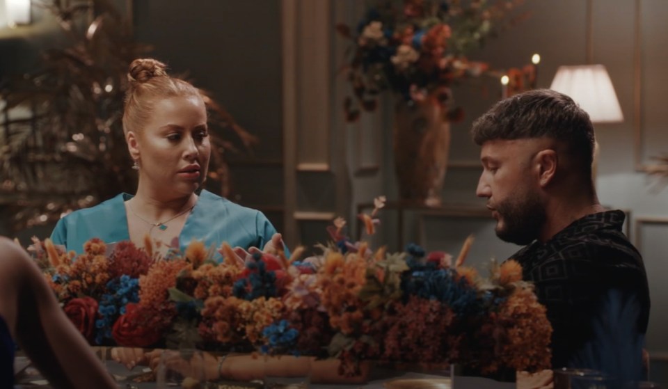 a man and a woman are sitting at a table with flowers