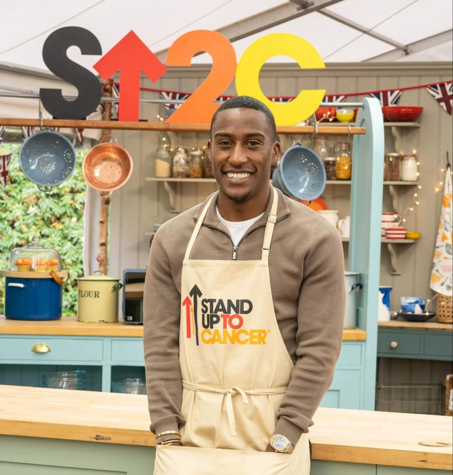 a man wearing an apron that says stand up to cancer