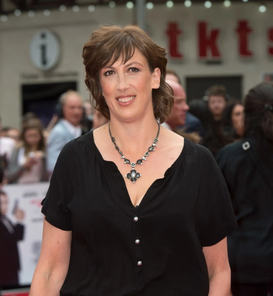 a woman stands on a red carpet in front of a sign that says tkt