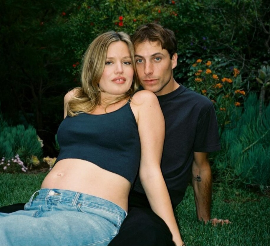 a man and a pregnant woman are posing for a picture