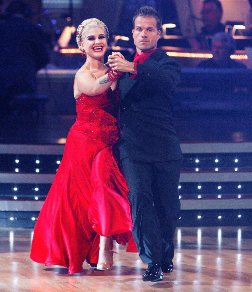 a woman in a red dress is dancing with a man in a black suit