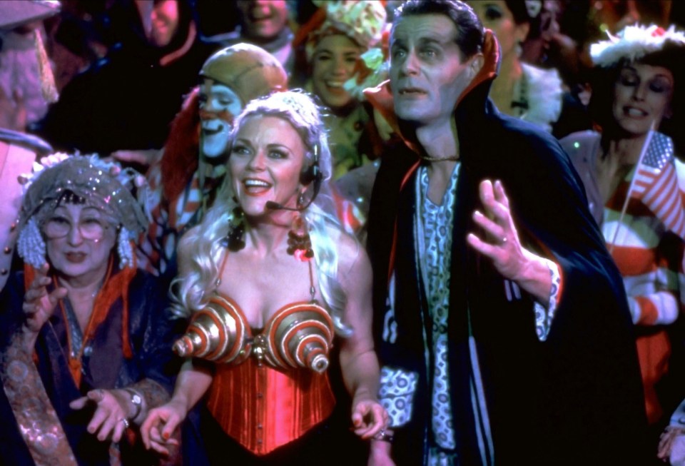 a man in a vampire costume stands next to a woman in a corset