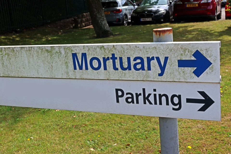 a sign pointing to the mortuary and parking