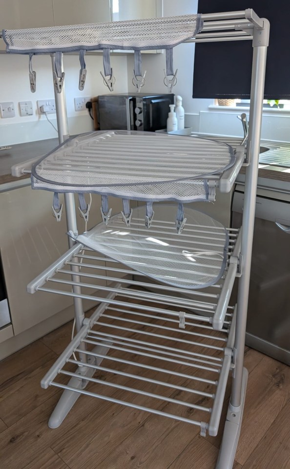 a clothes drying rack with clothes hanging on it