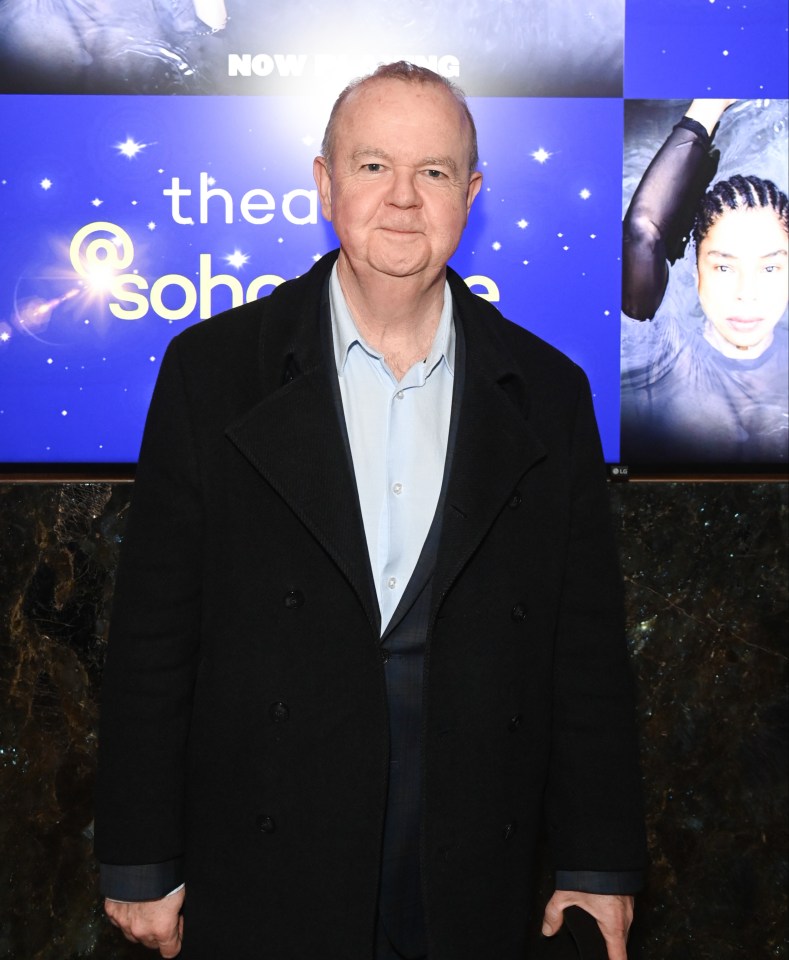 a man stands in front of a medea poster