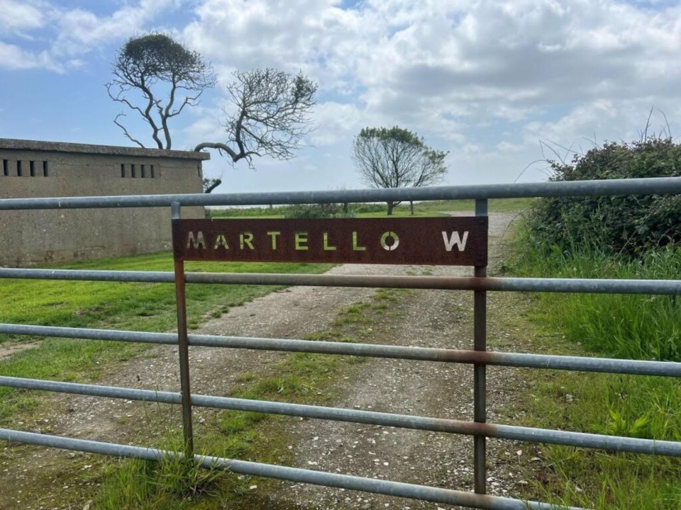 a rusty metal gate with a sign that says martello w