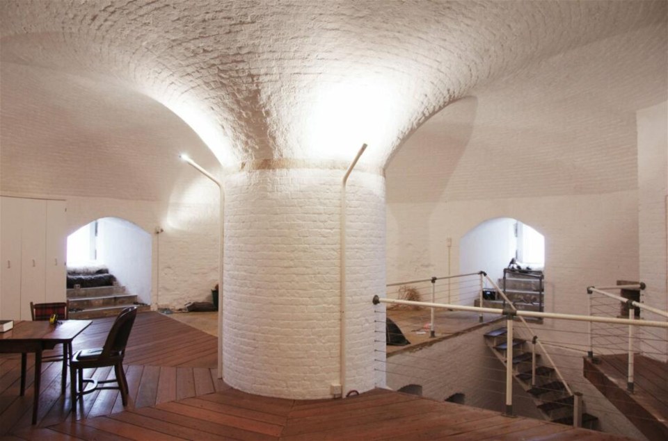 a room with a white brick wall and stairs