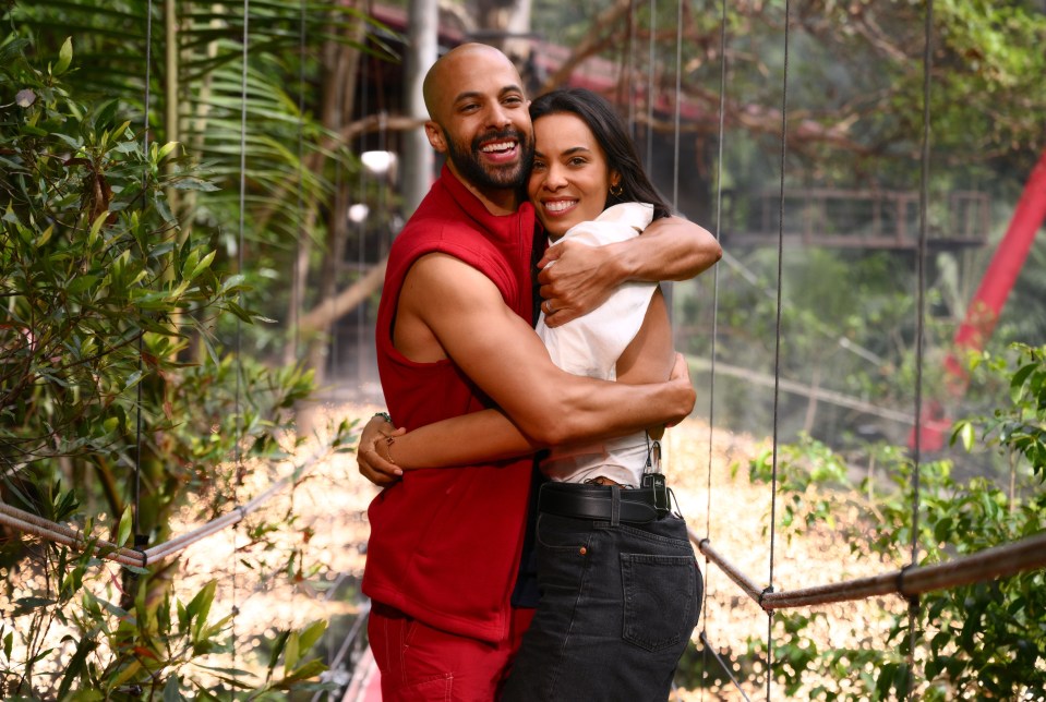 a man in a red robe is hugging a woman in a white shirt