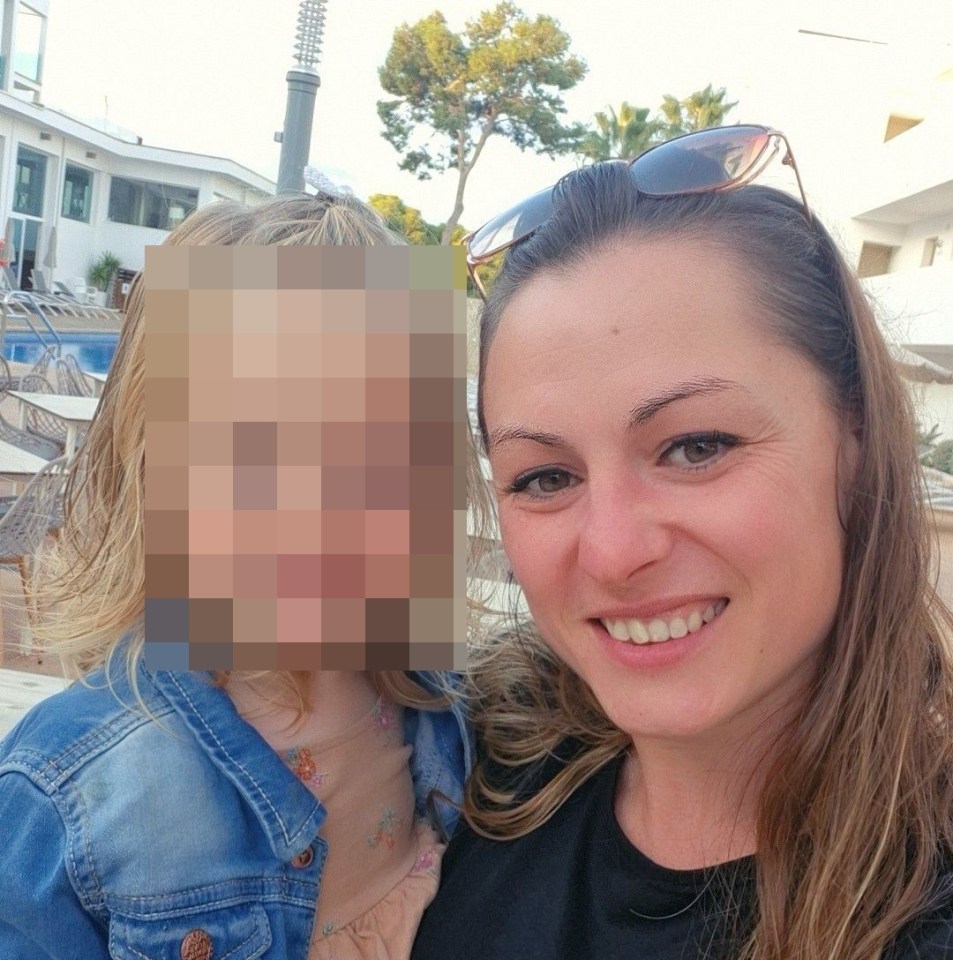 a woman is holding a little girl whose face is blurred