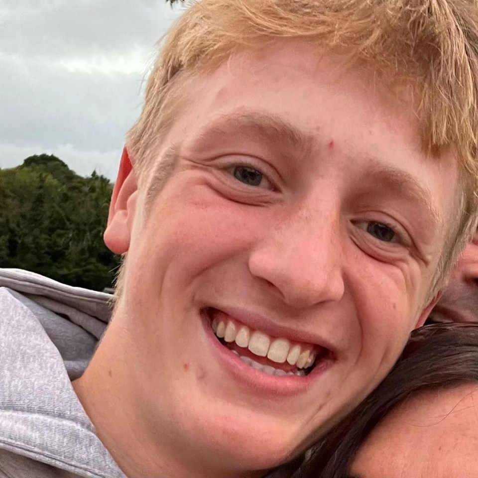 a young man with blonde hair is smiling for the camera