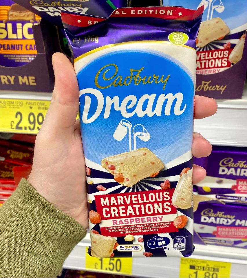 a person is holding a bag of cadbury dream marvellous creations raspberry