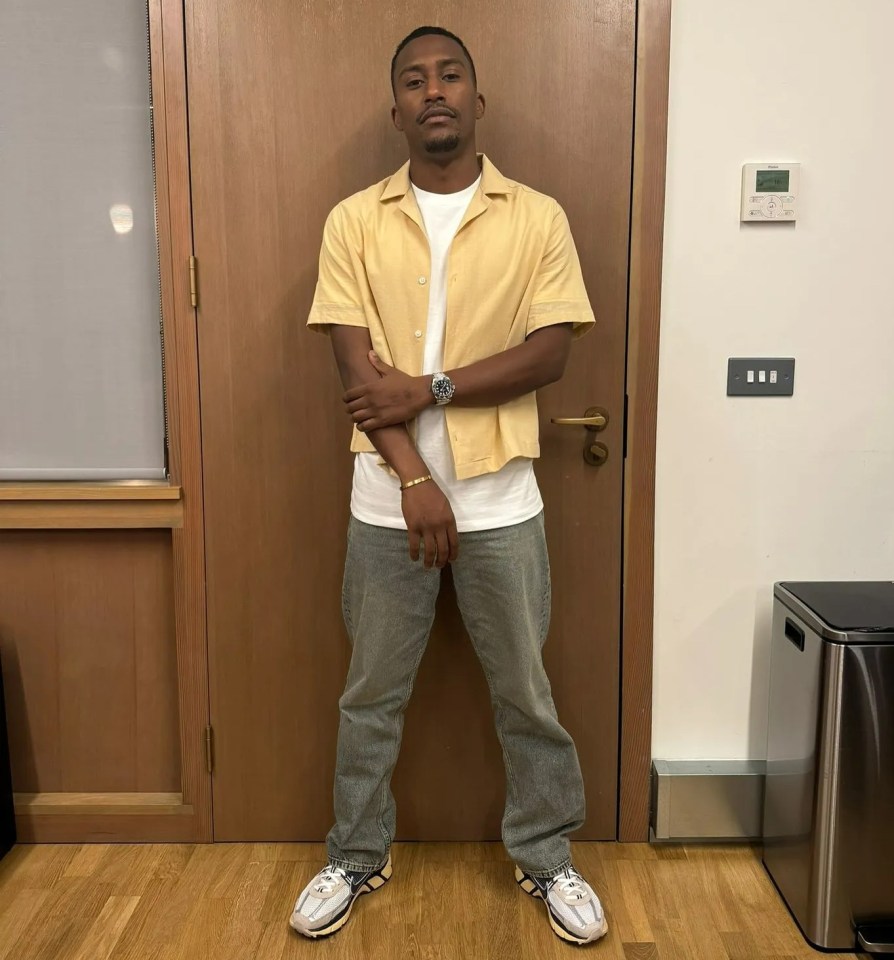 a man in a yellow shirt stands in front of a wooden door