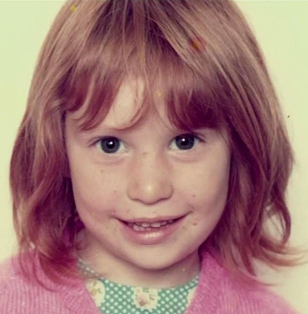 a little girl with red hair is smiling for the camera