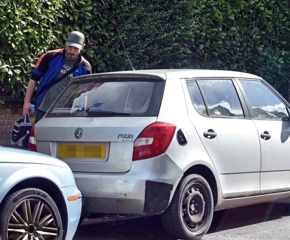 a man standing next to a white skoda car