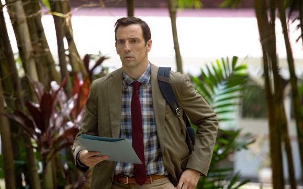 a man in a plaid shirt and tie is holding a piece of paper