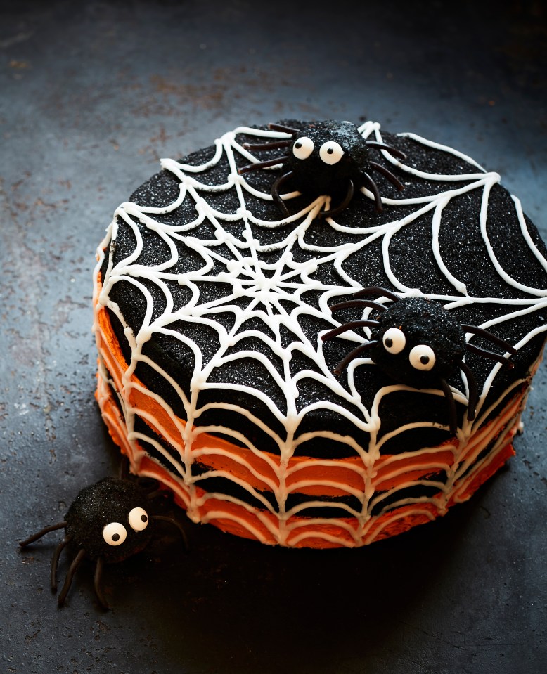 a cake with spiders and a spider web on it