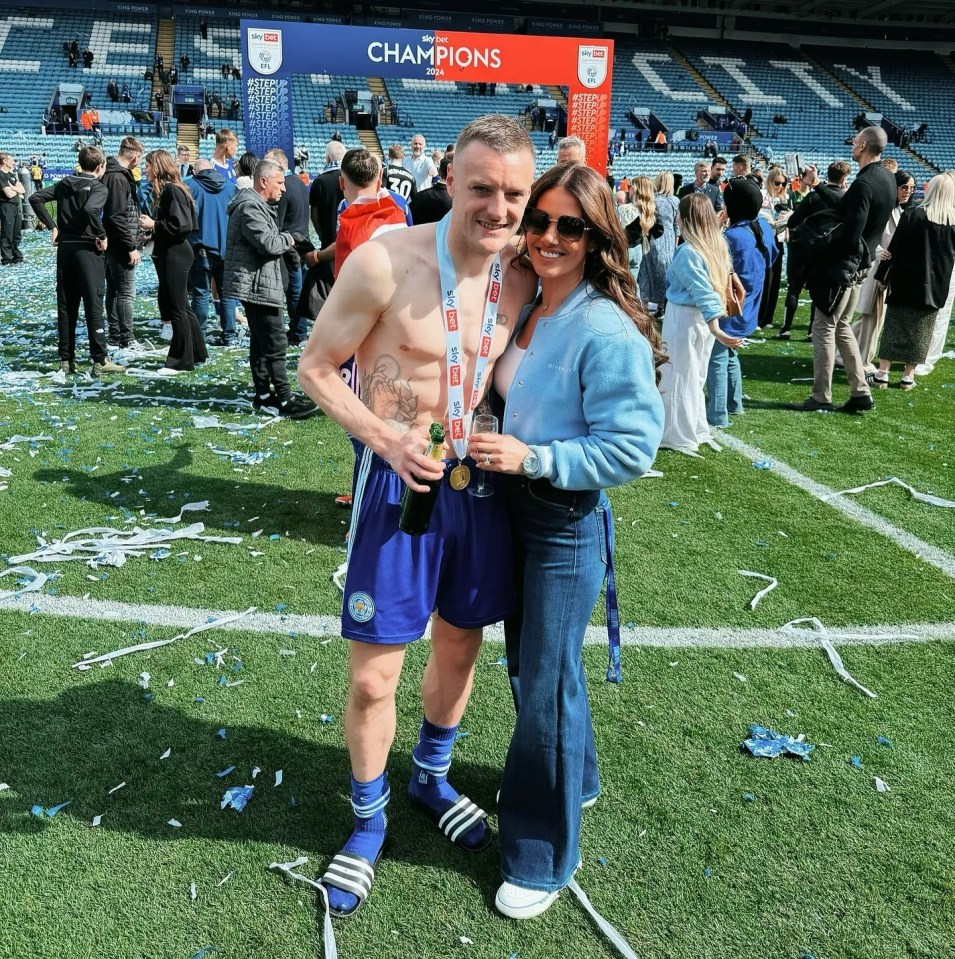 a man and a woman are posing for a picture in front of a sign that says champions