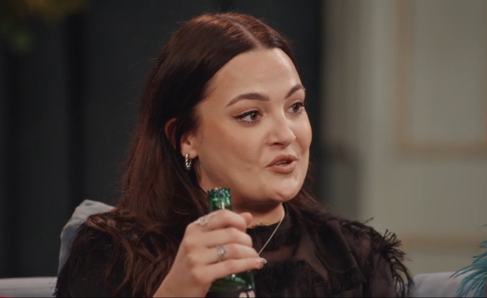 a woman sitting on a couch holding a green bottle