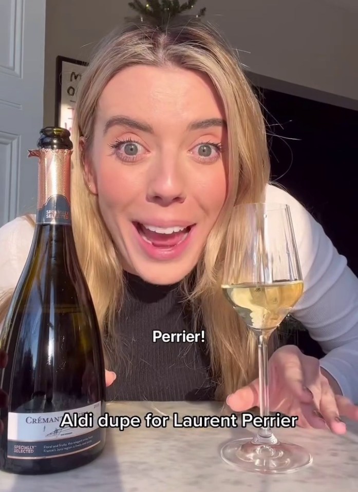 a woman is holding a bottle of laurent perrier wine