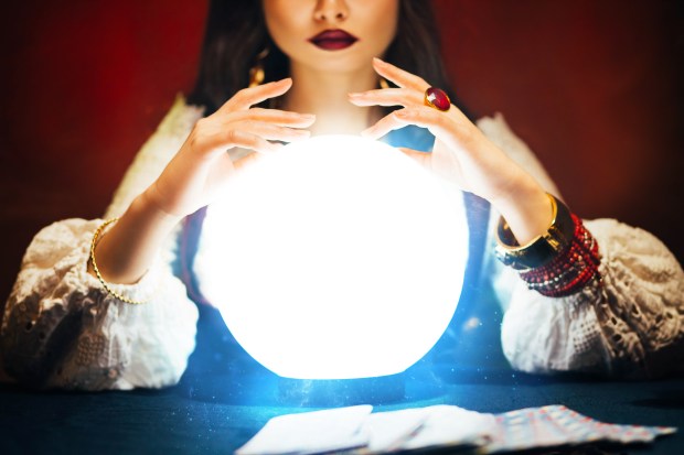 Fantasy beautiful retro women's hands close-up, look feel energy of crystal ball in dark gothic room. Photo of old art vintage astrology. Fortune teller woman reading future on magical tarot cards.