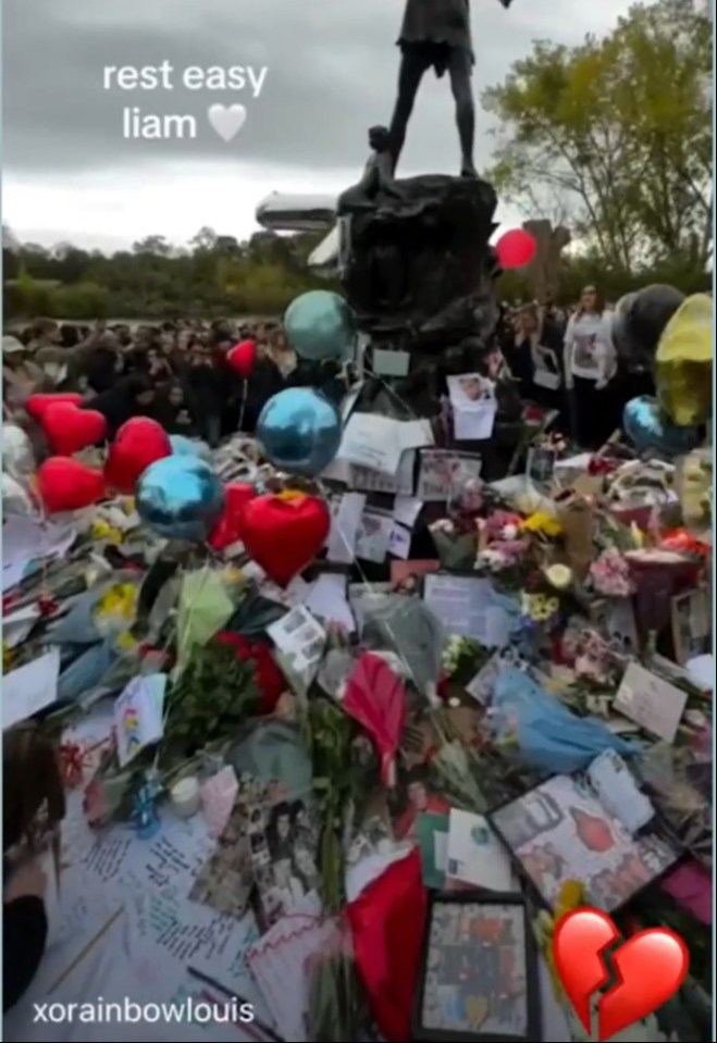 a pile of flowers and balloons with the words rest easy liam