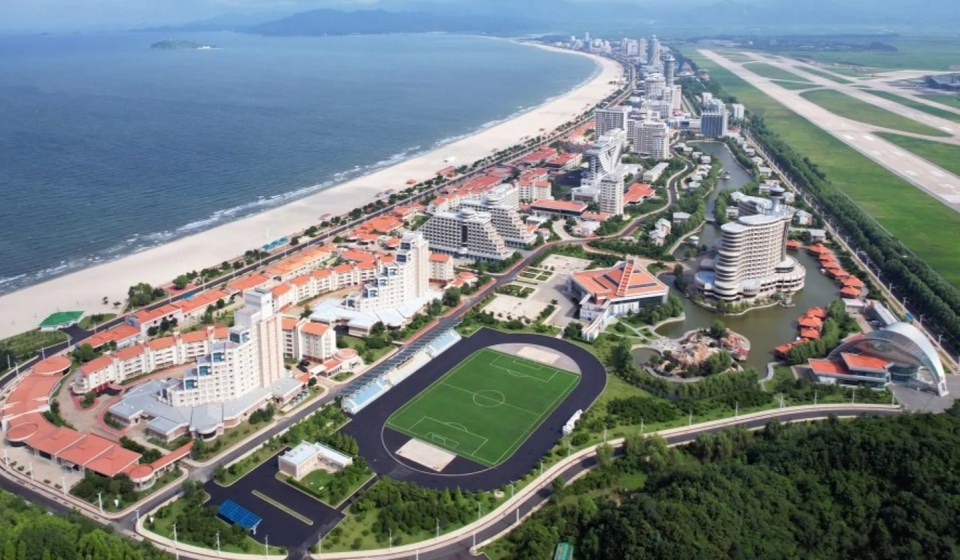 an aerial view of a city with a soccer field in the middle