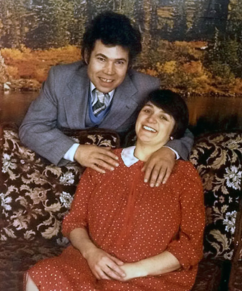 a man and a woman are posing for a picture and the man is wearing a suit and tie