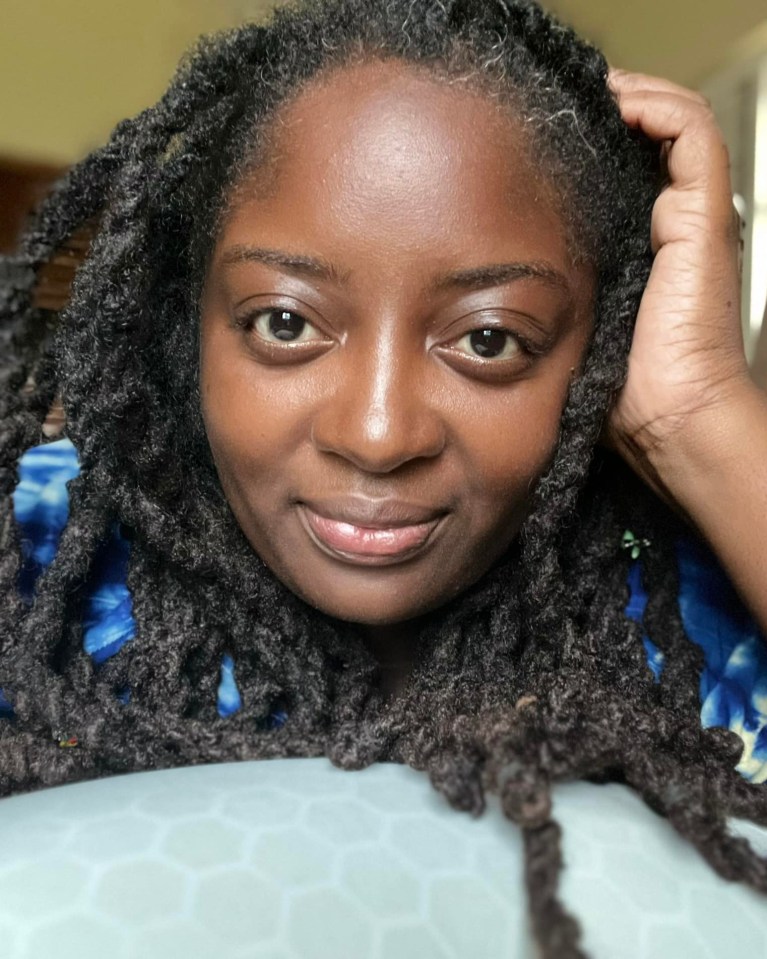 a woman with dreadlocks has her hand on her head