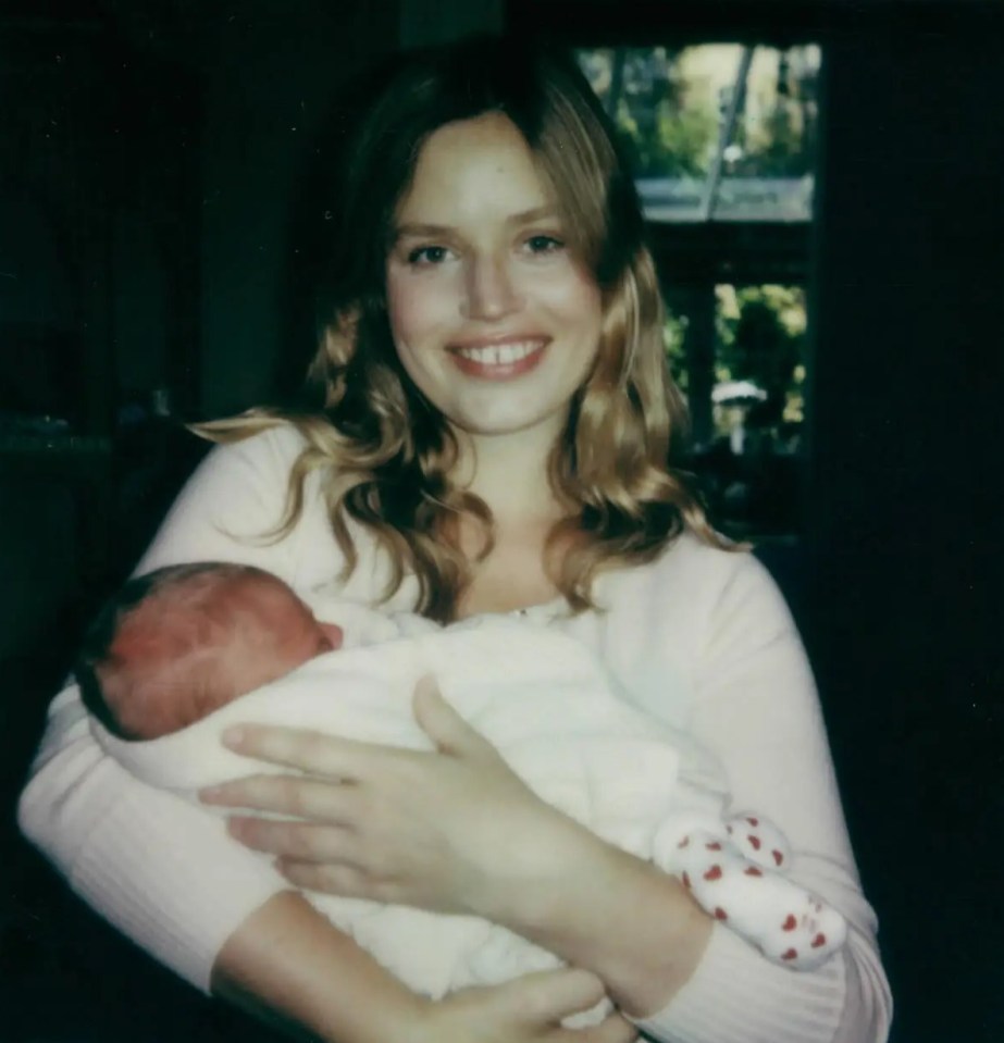 a woman is holding a baby in her arms and smiling