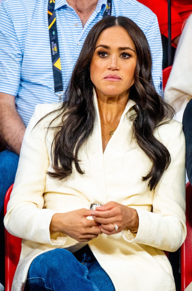 a woman in a white coat sits in a crowd