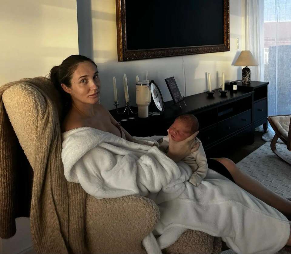 a woman is sitting in a chair holding a baby