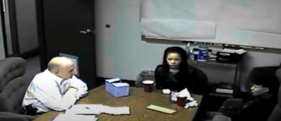 a man and two women sit at a table in a dark room