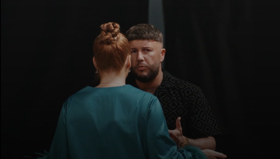 a man with a beard talks to a woman with red hair